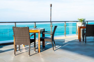 veranda sandalye ve masa deniz görünümü arka plan ile