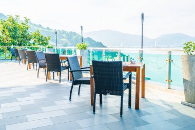 veranda sandalye ve masa deniz görünümü arka plan ile
