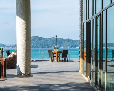 veranda sandalye ve masa deniz görünümü arka plan ile