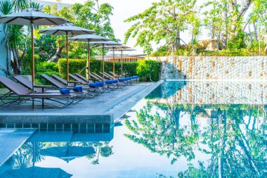Güzel şemsiye ve sandalye etrafında yüzme havuzunda otel ve r