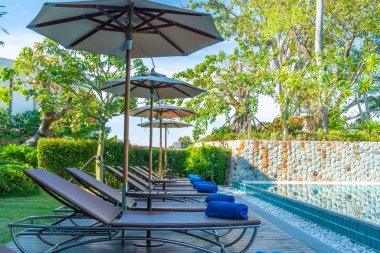 Güzel şemsiye ve sandalye etrafında yüzme havuzunda otel ve r