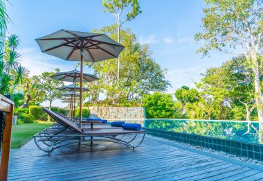 Güzel şemsiye ve sandalye etrafında yüzme havuzunda otel ve r