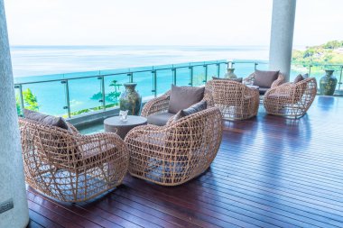 veranda sandalye ve masa deniz görünümü arka plan ile