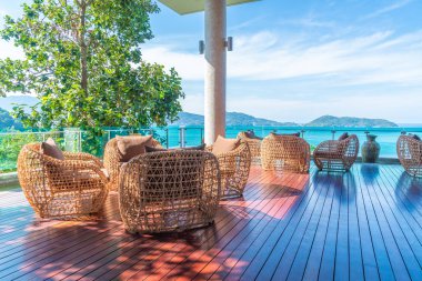 veranda sandalye ve masa deniz görünümü arka plan ile