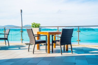 veranda sandalye ve masa deniz görünümü arka plan ile