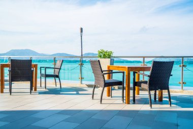 veranda sandalye ve masa deniz görünümü arka plan ile