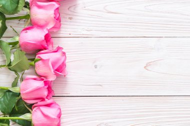 Ahşap arka plan üzerinde cam vazo içinde pembe Gül