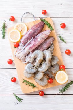 taze deniz ürünleri ham (karides, mürekkep) ahşap tahta üzerinde 