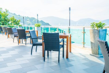 veranda sandalye ve masa deniz görünümü arka plan ile