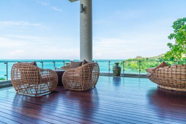 veranda sandalye ve masa deniz görünümü arka plan ile