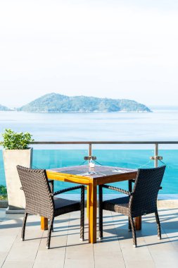 veranda sandalye ve masa deniz görünümü arka plan ile