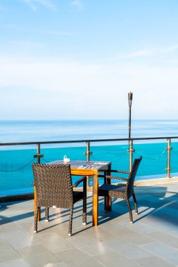 veranda sandalye ve masa deniz görünümü arka plan ile