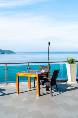 veranda sandalye ve masa deniz görünümü arka plan ile