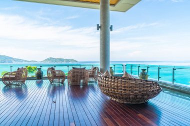 veranda sandalye ve masa deniz görünümü arka plan ile