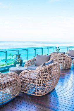 veranda sandalye ve masa deniz görünümü arka plan ile