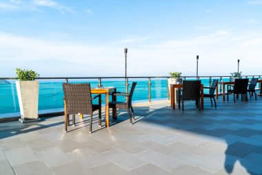 veranda sandalye ve masa deniz görünümü arka plan ile