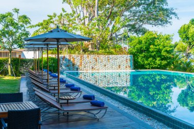 Güzel şemsiye ve sandalye etrafında yüzme havuzunda otel ve r