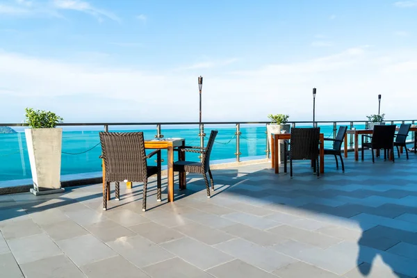 veranda sandalye ve masa deniz görünümü arka plan ile