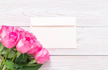 Ahşap arka plan üzerinde cam vazo içinde pembe Gül