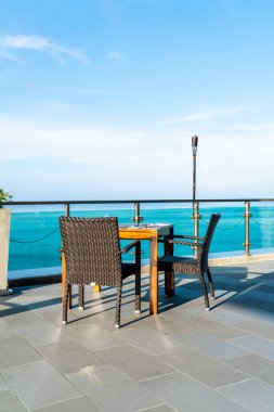 veranda sandalye ve masa deniz görünümü arka plan ile