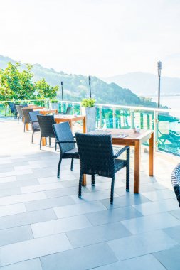 veranda sandalye ve masa deniz görünümü arka plan ile