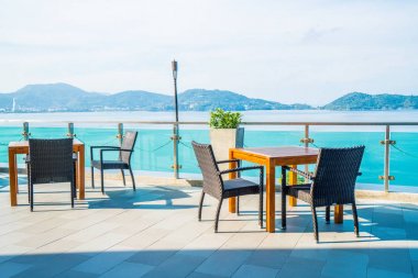 veranda sandalye ve masa deniz görünümü arka plan ile