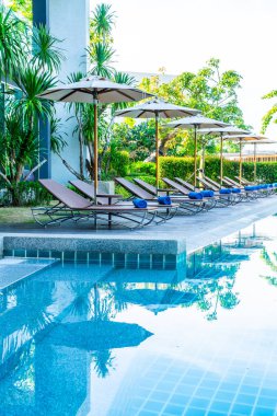 Güzel şemsiye ve sandalye etrafında yüzme havuzunda otel ve r