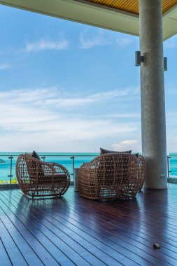 veranda sandalye ve masa deniz görünümü arka plan ile
