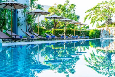 Güzel şemsiye ve sandalye etrafında yüzme havuzunda otel ve r