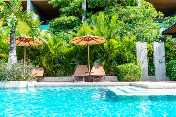 Parapluie et chaise autour de la piscine dans l'hôtel et station balnéaire — Photo