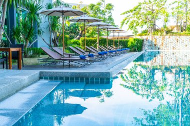 Güzel şemsiye ve sandalye etrafında yüzme havuzunda otel ve r