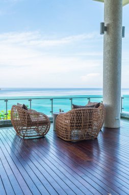 veranda sandalye ve masa deniz görünümü arka plan ile