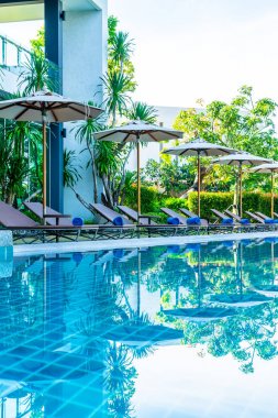 Güzel şemsiye ve sandalye etrafında yüzme havuzunda otel ve r