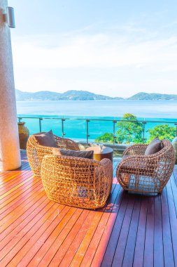 veranda sandalye ve masa deniz görünümü arka plan ile