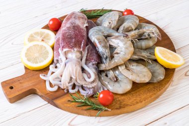 taze deniz ürünleri ham (karides, mürekkep) malzemelerle ahşap tahta üzerinde