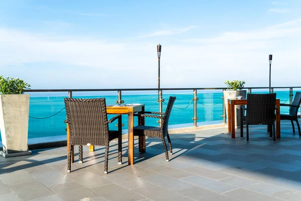 empty patio chair and table with sea view background