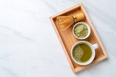 Yeşil çay tozu ve çırpılmış sıcak kibrit yeşil çay fincanı.