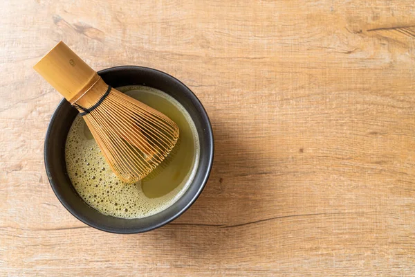 hot matcha green tea cup with green tea powder and whisk