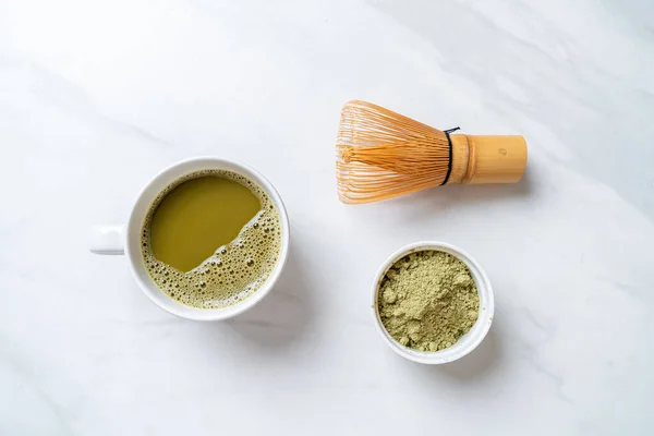 hot matcha green tea cup with green tea powder and whisk