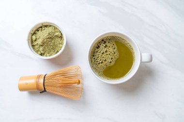 Yeşil çay tozu ve çırpılmış sıcak kibrit yeşil çay fincanı.
