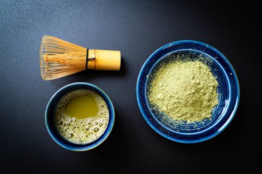 Yeşil çay tozu ve çırpılmış sıcak kibrit yeşil çay fincanı.