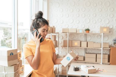 Asya kadın iş sahibi çalışan evde ambalaj kutusu ile w