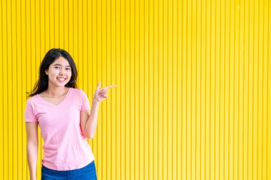 sarı duvar üzerinde ayakta Genç Asyalı kadın mutluluk