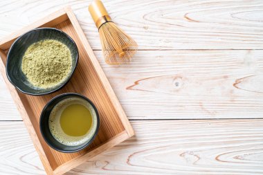 Yeşil çay tozu ve çırpılmış sıcak kibrit yeşil çay fincanı.