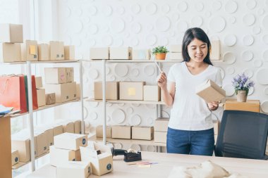 Asya kadın iş sahibi çalışan evde ambalaj kutusu ile w