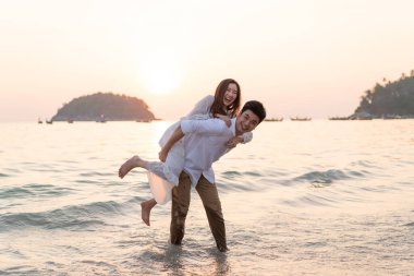 Mutlu çift balayı gidiş tropikal kum plajı üzerinde su içinde seyahat.