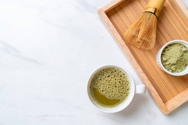 Yeşil çay tozu ve çırpılmış sıcak kibrit yeşil çay fincanı.