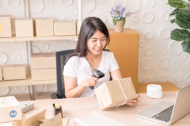 Asya kadın iş sahibi çalışan evde ambalaj kutusu ile w