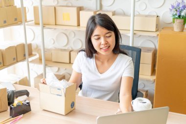 Asya kadın iş sahibi çalışan evde ambalaj kutusu ile w
