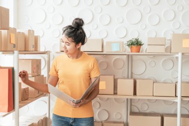  Genç Asyalı kadın ambar stok raf üzerinde mal kontrol